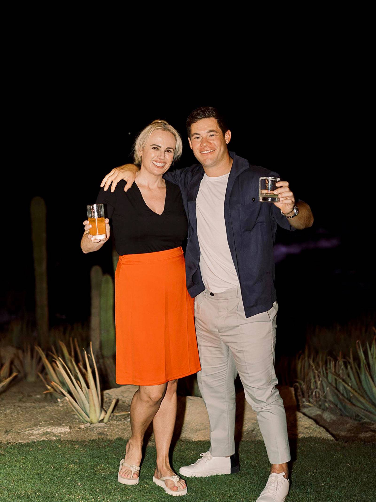 Adam i Rebel Wilson raczą się drinkami na przyjęciu powitalnym.