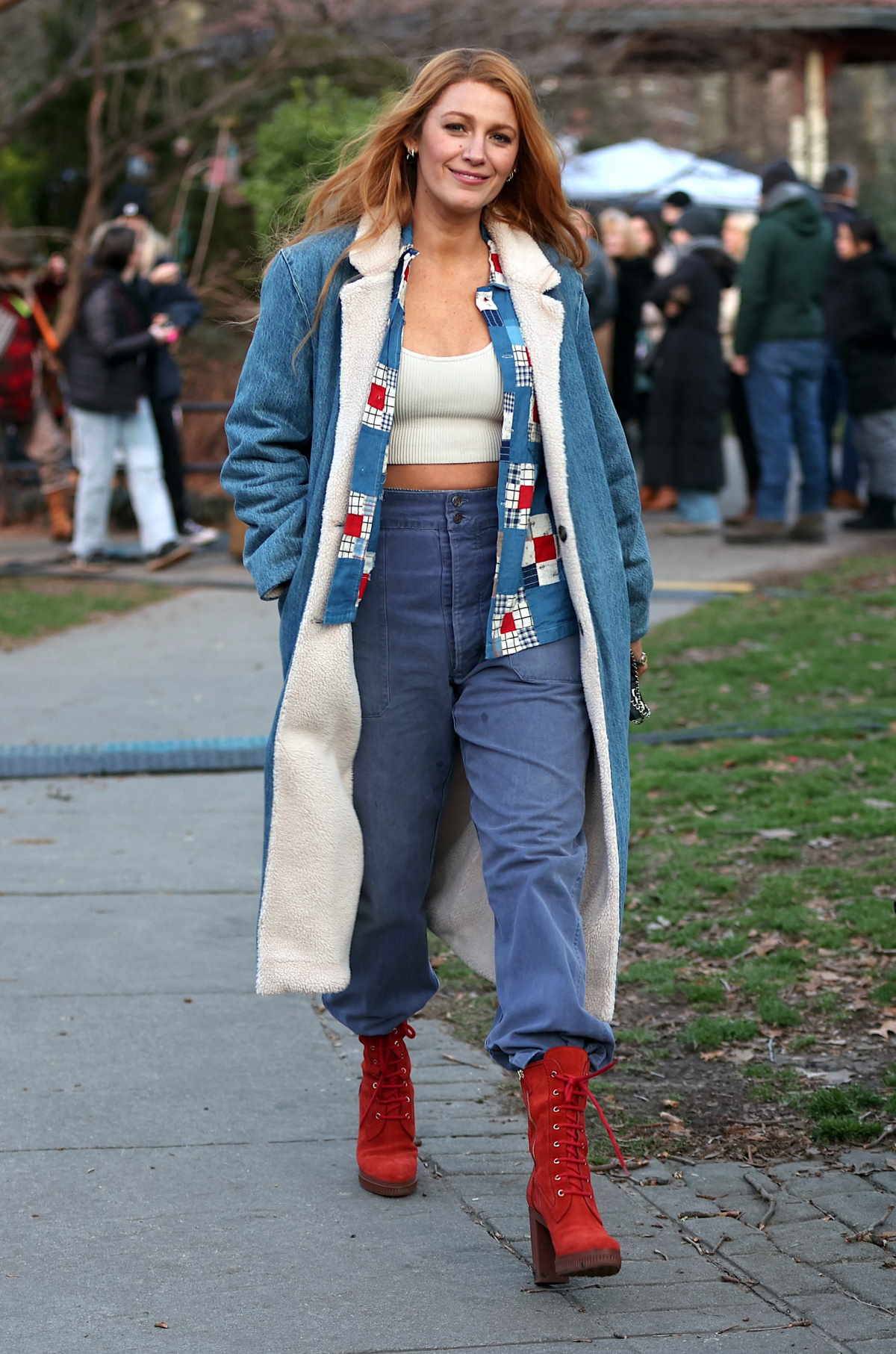 Stylizacja Blake Lively w szerokich jeansach i jeansowym płaszczu, czerwonych botkach na platformie.