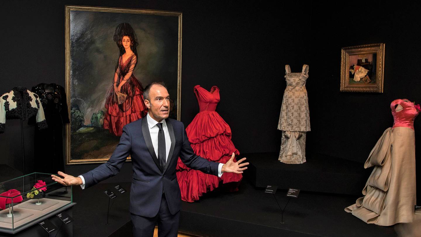 The Balenciaga exhibition curator, Eloy Martinez de la Pera, with the designers scarlet 1952 gown inspired by a 1921 portrait of the Duchess of Alba by Ignacio Zuloaga. Credit: @BORJALAMA