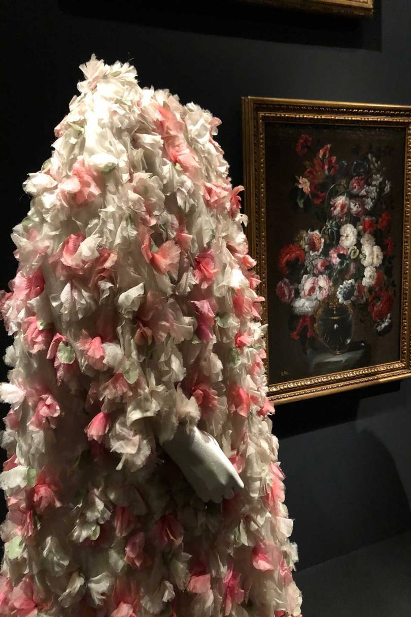 A Balenciaga organza evening coat with floral applications (1964) set against the still-life by Gabriel de la Corte, Flowers in a vase (second-half of the 17th century). Credit: NATASHA COWAN