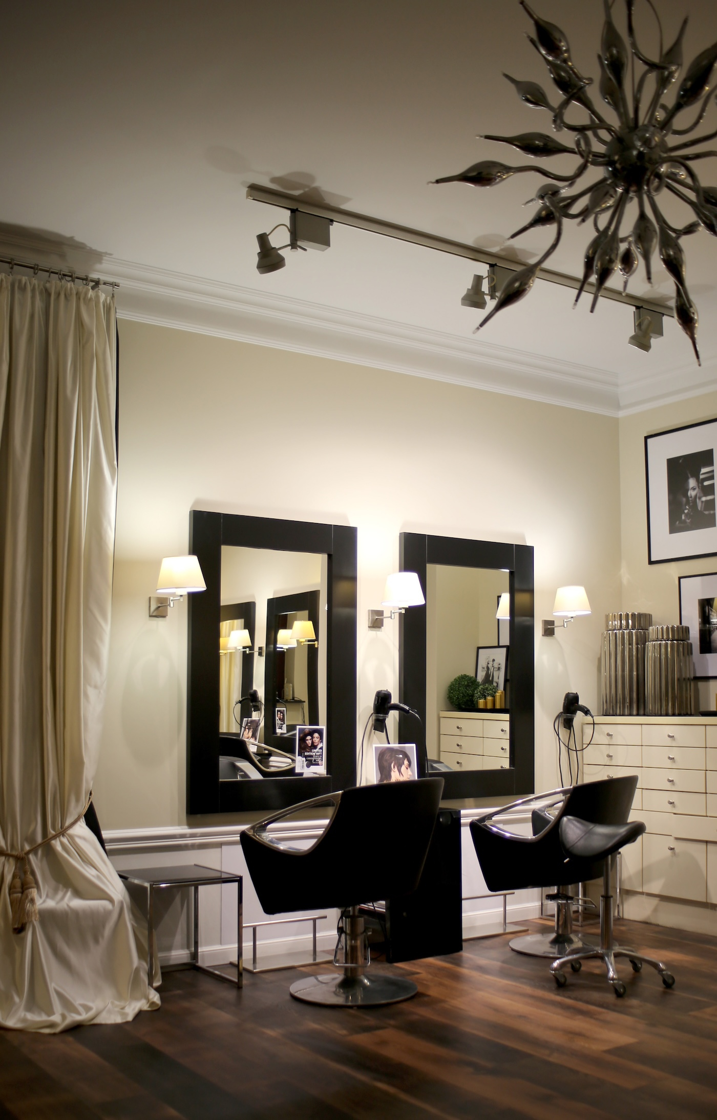 Nowoczesny salon fryzjerski MIGDAL z dwoma lustrami, stylowymi fotelami i eleganckim oświetleniem.