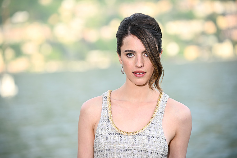 Margaret Qualley w eleganckiej kreacji Chanel, ujęta na tle wodnego krajobrazu.
