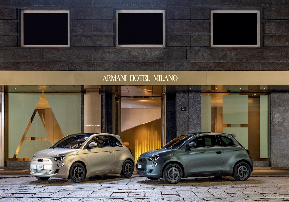 Samochody Fiat 500e Giorgio Armani w kolorze szarobeżowym i ciemnozielonym stoją przed hotelem Armani w Mediolanie.