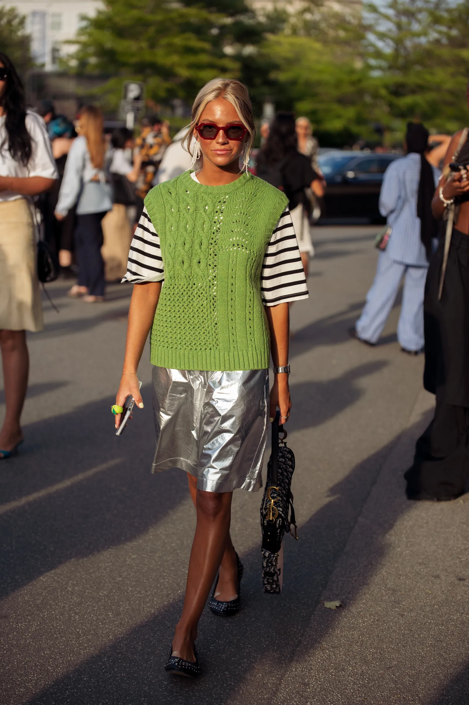 Street style: zielona dzianinowa kamizelka w połączeniu z koszulką w paski i srebrną spódnicą. (Fot. Raimonda Kulikauskiene/Getty Images)