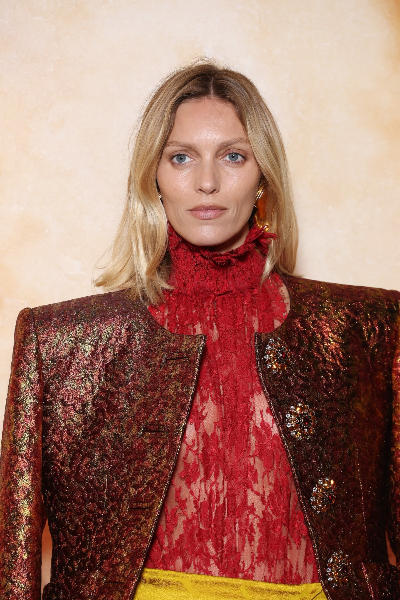 Anja Rubik w żakiecie bez klap w stylu retro z brokatowej tkaniny, golfie z czerwonej koronki i żółtej, satynowej spódniczce z falbankami.