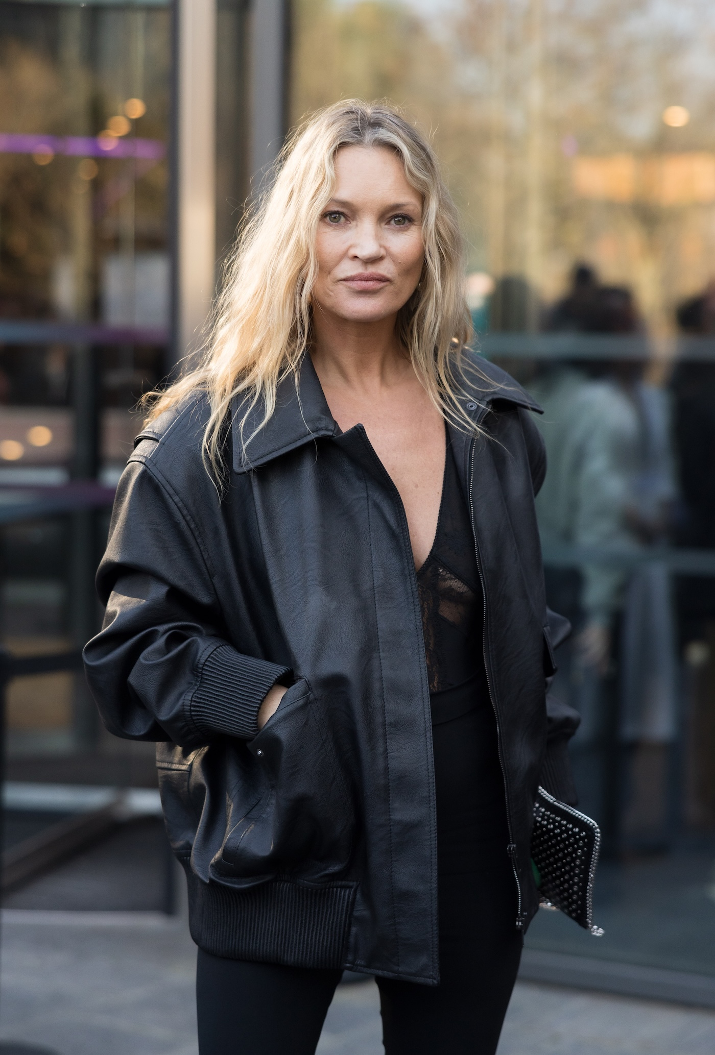Kate Moss ma na sobie oversize'ową czarną bomberka z wegańskiej skóry marki Stella McCartney oraz obcisłe czarne skinny jeans.
