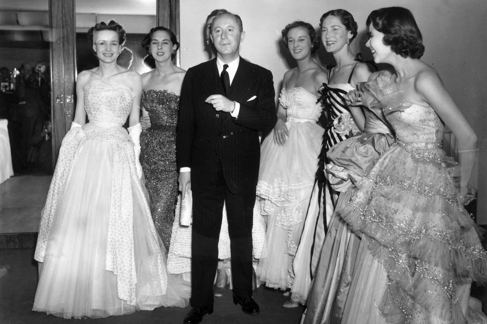 Christian Dior w towarzystwie sześciu modelek po swoim pokazie, przed hotelem Savoy w Londynie, 1950 rok (Fot. Getty Images)